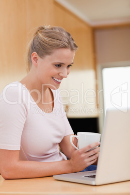 Portrait of a woman using a notebook while drinking a cup of a t