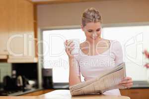 Woman reading the news while having tea