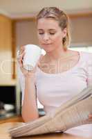 Portrait of a cute woman reading the news while having tea