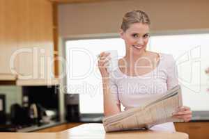 Young woman reading the news while having coffee