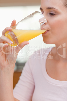 Portrait of a calm woman drinking orange juice