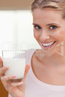 Portrait of a young woman drinking a glass of milk