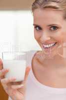 Portrait of a young woman drinking a glass of milk