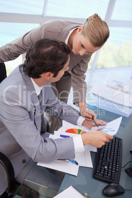 Portrait of a manager pointing at something to her secretary on