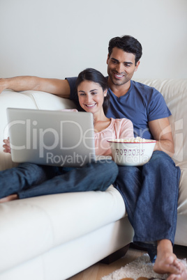 Portrait of a couple watching a movie while eating popcorn