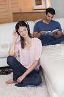 Portrait of a woman listening to music while her fiance is readi