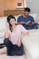 Portrait of a woman listening to music while her boyfriend is re