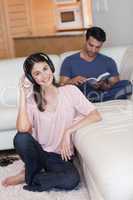 Portrait of a young woman listening to music while her fiance is