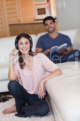 Portrait of a young woman listening to music while her husband i
