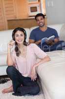 Portrait of a young woman listening to music while her husband i