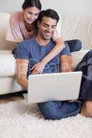 Portrait of a happy couple using a notebook