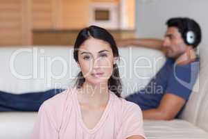 Woman posing while her boyfriend is listening to music