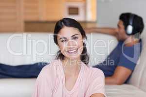 Woman posing while her fiance is listening to music