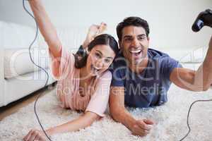 Laughing young couple playing video games