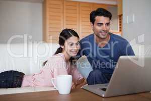 Young couple using a laptop while having a coffee