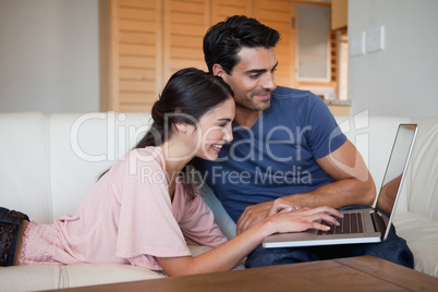 Smiling young couple using a laptop