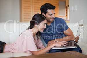 Smiling young couple using a laptop