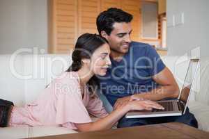 Charming young couple using a laptop