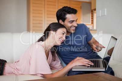 Lovely young couple using a laptop