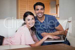 Lovely young couple using a notebook