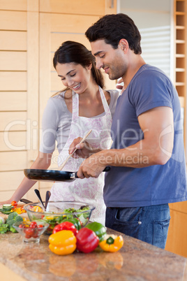 Portrait of a couple cooking with a pan