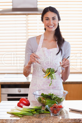 Portrait of a woman preparing a salad