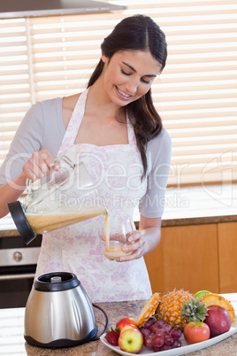 Portrait of a woman pouring fresh juice in a glass