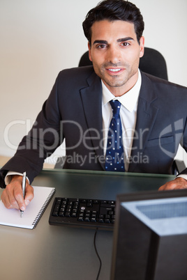 Portrait of a handsome businessman taking notes