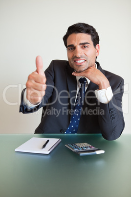 Portrait of a young accountant with the thumb up