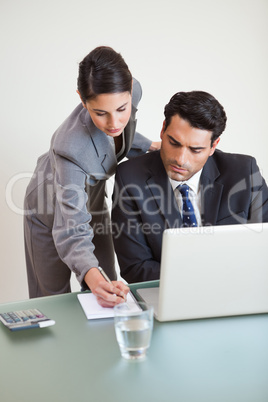 Portrait of a good looking business team working with a laptop