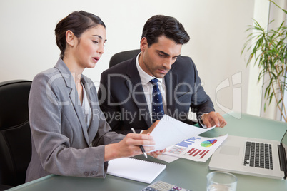 Sales persons working with a notebook
