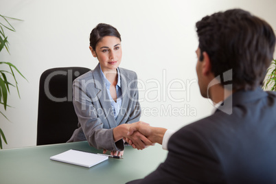 Young manager shaking the hand of a customer