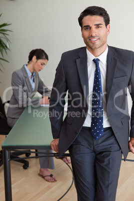 Portrait of a handsome businessman posing while his colleague is