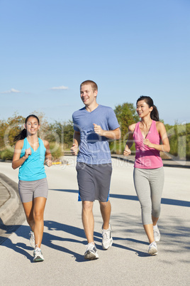 Three Interracial Young Adult Friends Running Jogging