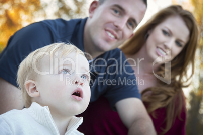 Cute Child Looks Up to Sky as Young Parents Smile