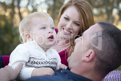 Cute Child Looks Up to Sky as Young Parents Smile