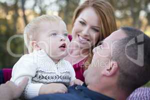 Cute Child Looks Up to Sky as Young Parents Smile