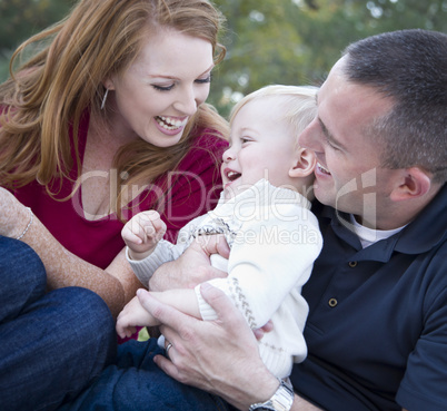 Attractive Young Parents Laughing with Child Boy in Park