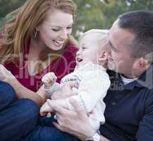 Attractive Young Parents Laughing with Child Boy in Park