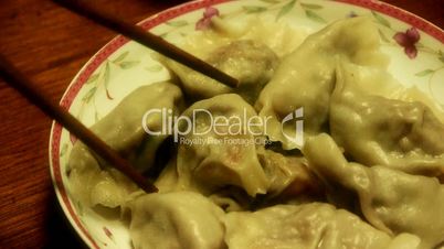 use chopsticks eating dumplings,tradition chinese new year delicious food.