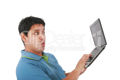 Young man standing, holding a laptop computer, working, looking