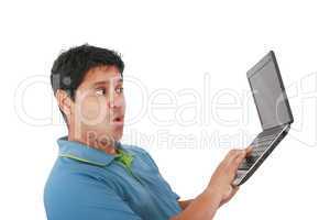 Young man standing, holding a laptop computer, working, looking