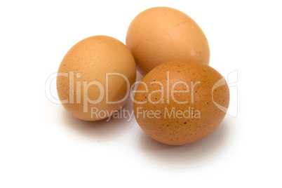 Three eggs lying down on a white linen background