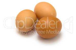 Three eggs lying down on a white linen background