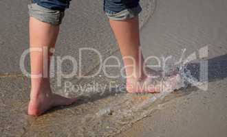Beine im Wasser bei einem Strandspaziergang