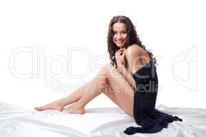 Young nude woman sit on white in knitted jacket