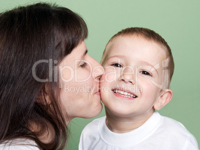 Mother kissing child