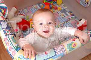 Smiling child playing in the cot, family scenes