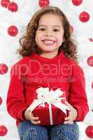 little girl sitting in front of a christmas tree