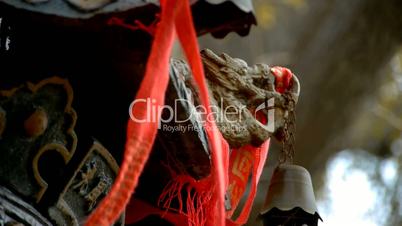 Dragon and metal bell on censer,Red ribbon blowing in wind.